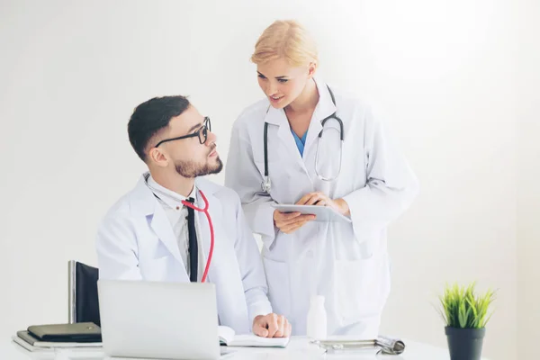 Médecin à l'hôpital travaille sur ordinateur avec partenaire . — Photo