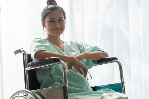 Happy patient sitting on wheelchair in hospital. Medical healthc