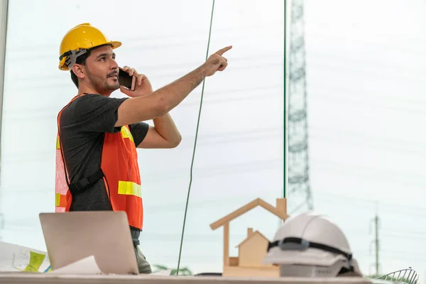 Ung man arkitekt eller ingenjör som arbetar vid skrivbordet. — Stockfoto