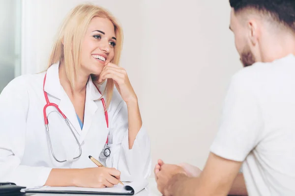 Donna medico e paziente maschile in ufficio ospedaliero — Foto Stock