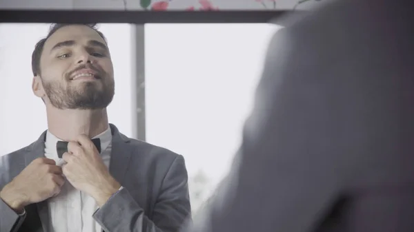 Man in formal suit getting dress in dressing room.