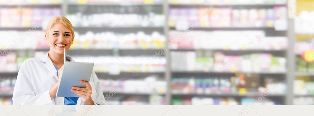 Pharmacist using tablet computer at pharmacy.