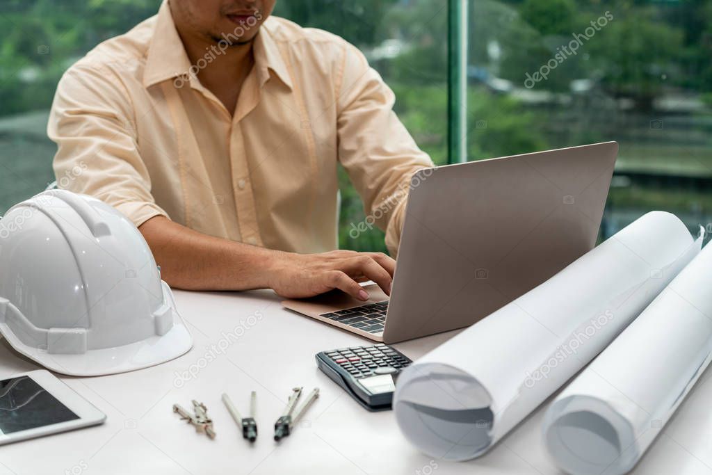 Young man architect or engineer working at desk.