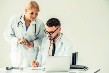 Hastanedeki doktor ortağıyla bilgisayar başında çalışıyor.