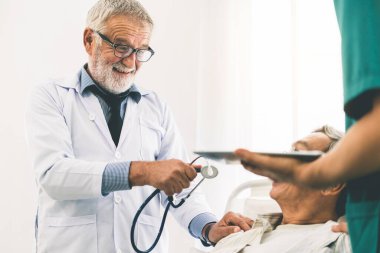 Söz ve sağlık hastane koğuşunda üst düzey hastanın inceleyerek olgun doktor. Tıbbi doktor ve sağlık personeli hizmet anlayışı.