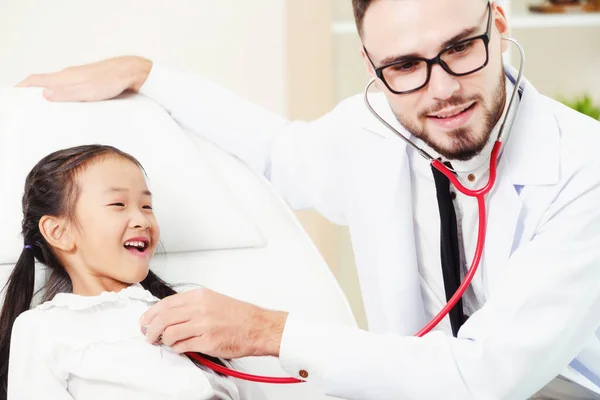 Médico examinando pequeño niño feliz en el hospital . — Foto de Stock