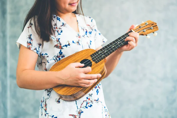 Boldog asszony zenész játszik ukulele stúdióban. — Stock Fotó