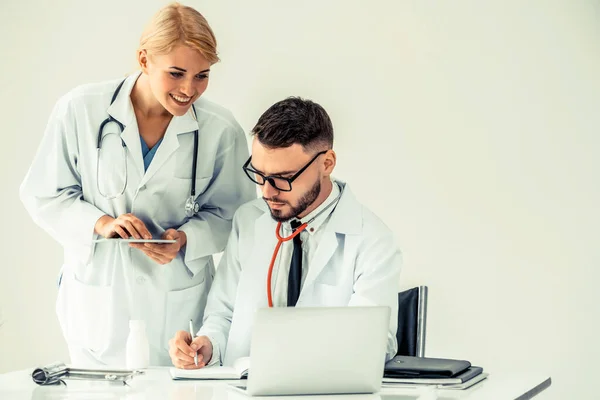 El médico en el hospital trabaja en el ordenador con el socio . — Foto de Stock