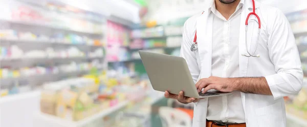 Farmacêutico usando computador portátil na farmácia . — Fotografia de Stock