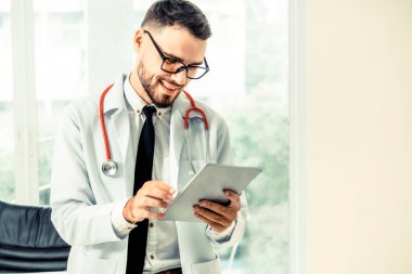 Hastanede tablet bilgisayar üzerinde çalışan doktor.