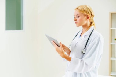 Hastane ofisinde çalışan genç kadın doktor.