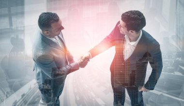 Arka planda iş adamları el sıkışma çift pozlama görüntü iş anlaşmasının ortaklık başarısını gösteren. Kurumsal ekip çalışması, güven ortağı ve iş sözleşmesi kavramı.