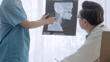 Doktor ve hemşire x-ray görüntü o ameliyat sonucu göstermek tartışmak