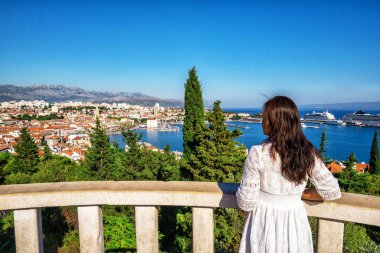Woman traveler travels to old town of Split in Dalmatia, Croatia. Split is the famous city and top tourism destination of Croatia and Europe. clipart