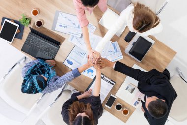 Takım çalışması çalışanları toplantıda el ele tutuşuyor.