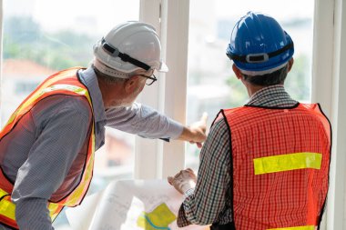 İnşaat planı ile çalışan kıdemli mühendis ve mimar. Ev bina konsepti.