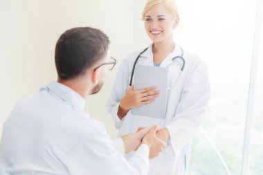 Hastanedeki doktor başka bir doktorla el sıkışıyor
