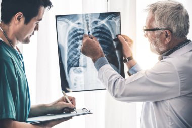 Hasta göğsünün x Ray filmi ile çalışan doktorlar.