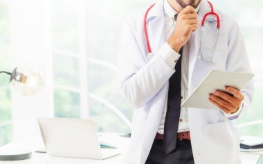 Hastanede tablet bilgisayar üzerinde çalışan doktor.