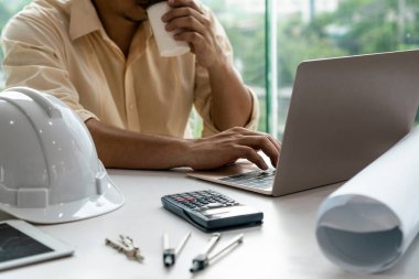 Masa başında çalışan genç mimar veya mühendis.