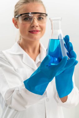 Kimya laboratuvarında çalışan ve biyokimya laboratuvar örneğini inceleyen genç kadın bilim adamı. Bilim teknolojisi tıp araştırma ve geliştirme çalışma konsepti.