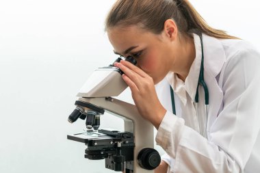 Hastane laboratuvarında mikroskop kullanan doktor.