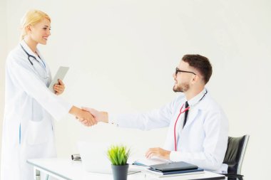 Hastanedeki doktor başka bir doktorla el sıkışıyor