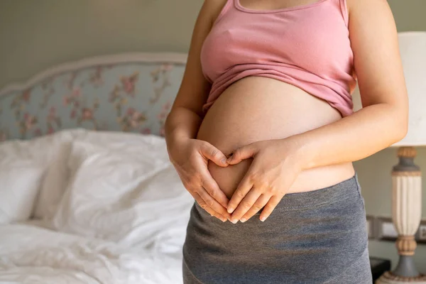 Mujer embarazada feliz y esperando un bebé en casa. — Foto de Stock