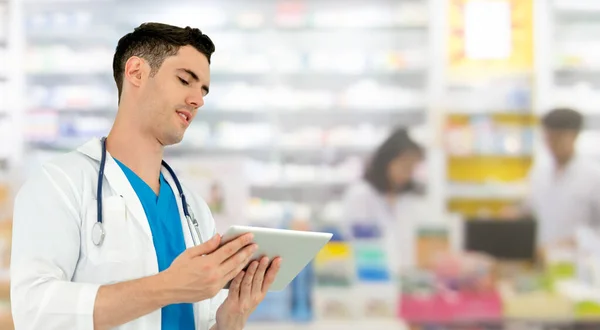Lékárník používající tabletový počítač v lékárně. — Stock fotografie