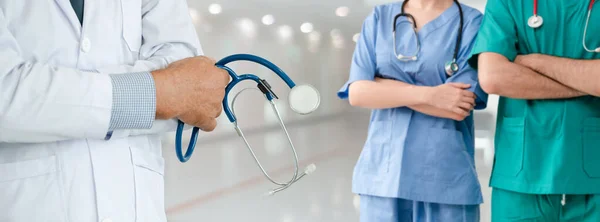 Médico que trabalha no hospital com outros médicos . — Fotografia de Stock