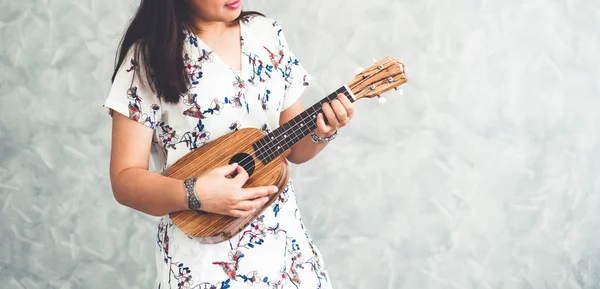 Mulher feliz músico tocando ukulele no estúdio . — Fotografia de Stock