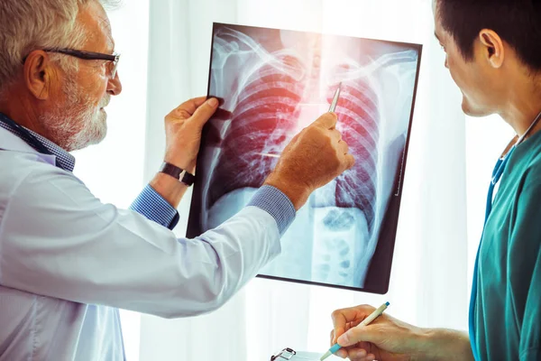 Médicos que trabalham com radiografia de tórax do paciente . — Fotografia de Stock