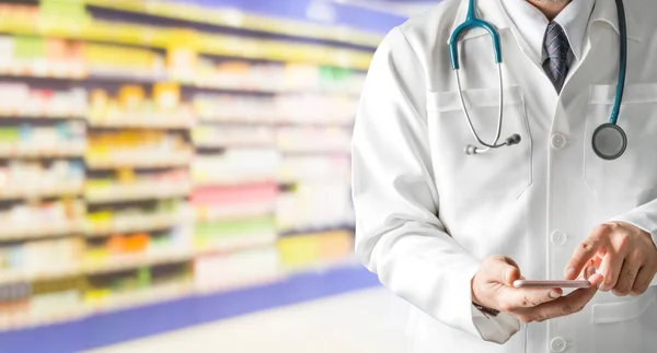 Farmacéutico masculino usando teléfono móvil en farmacia . — Foto de Stock