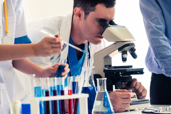 Group of scientists working in chemical lab.