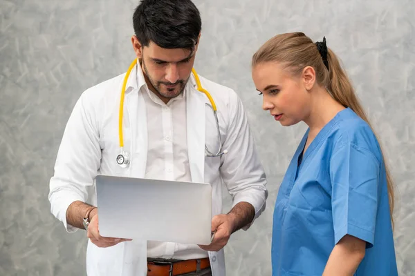 Médico y enfermera trabajando con computadora portátil . — Foto de Stock