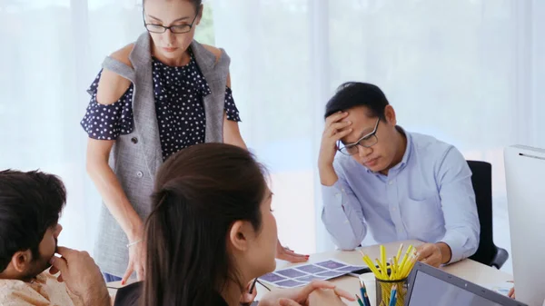 Unhappy business people in group meeting in office. The team is frustrated because of project failure. Business problem and crisis concept.