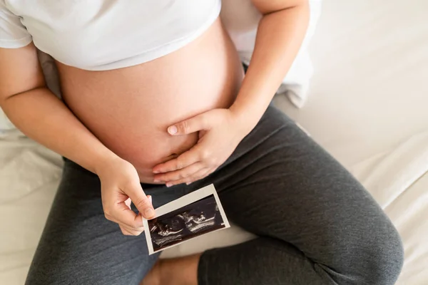 Mujer embarazada feliz y esperando un bebé en casa. — Foto de Stock