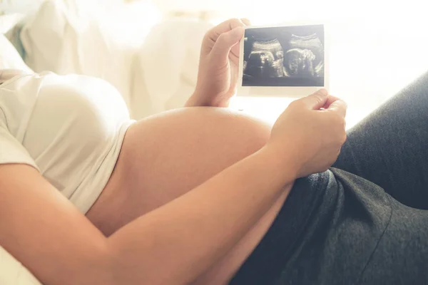 Mujer embarazada feliz y esperando un bebé en casa. — Foto de Stock