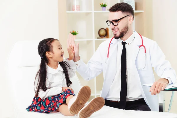 Dokter onderzoekt weinig gelukkig kind in het ziekenhuis. — Stockfoto