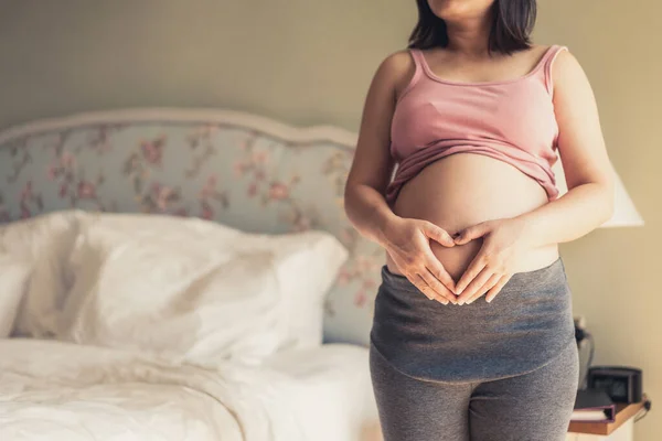 Mujer embarazada feliz y esperando un bebé en casa. — Foto de Stock