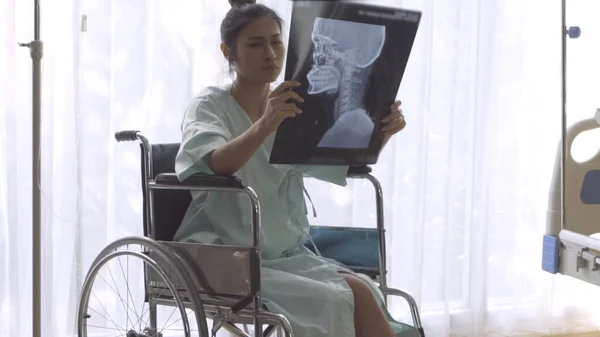 Paciente seria mirando la imagen de rayos X de su aumento de lesiones cerebrales — Foto de Stock