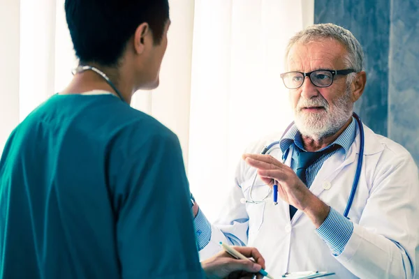 Médico senior masculino que trabaja con otro médico . — Foto de Stock