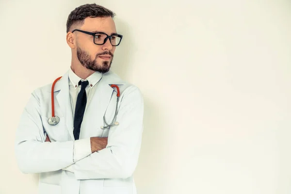 Joven médico con brazos cruzados sobre fondo blanco . — Foto de Stock