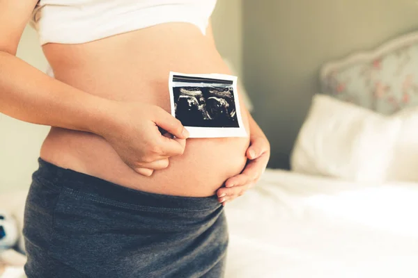 Mujer embarazada feliz y esperando un bebé en casa. — Foto de Stock