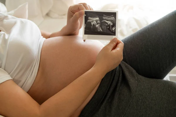 Mujer embarazada feliz y esperando un bebé en casa. — Foto de Stock