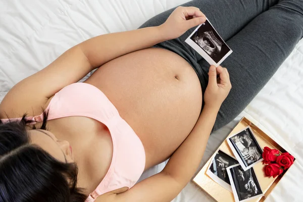 Mujer embarazada feliz y esperando un bebé en casa. — Foto de Stock