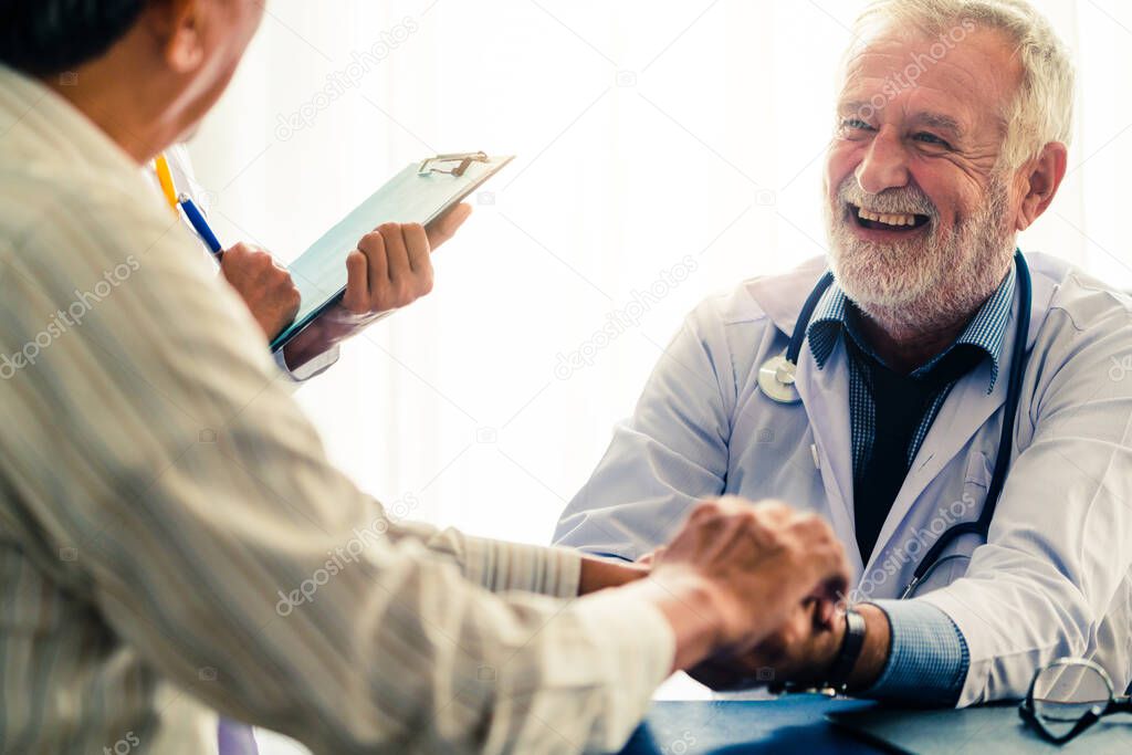 Senior male doctor talking to elder man patient in the hospital office. Medical healthcare and doctor staff service concept.