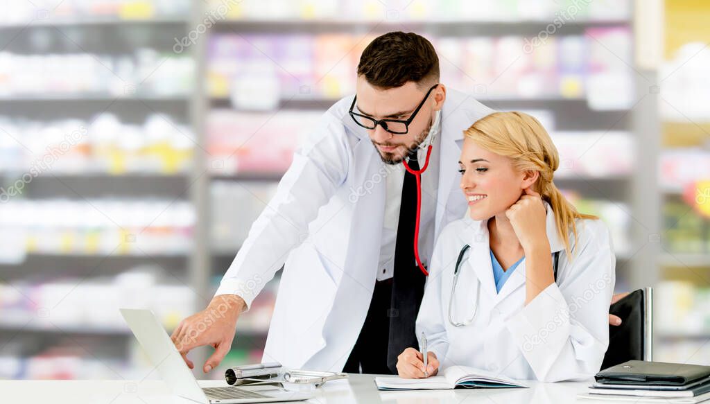 Doctors working with laptop computer in hospital.