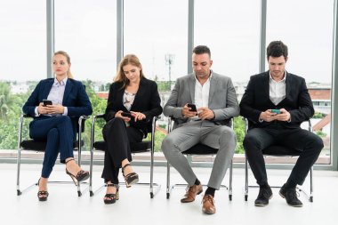 Cep telefonu kullanan iş kadınları ve işadamları.