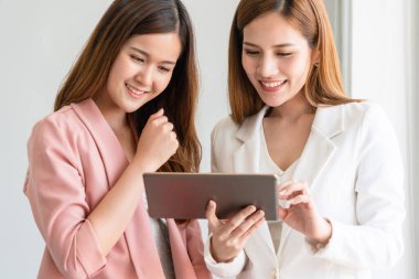 Ofiste tablet bilgisayar kullanan iş kadınları.